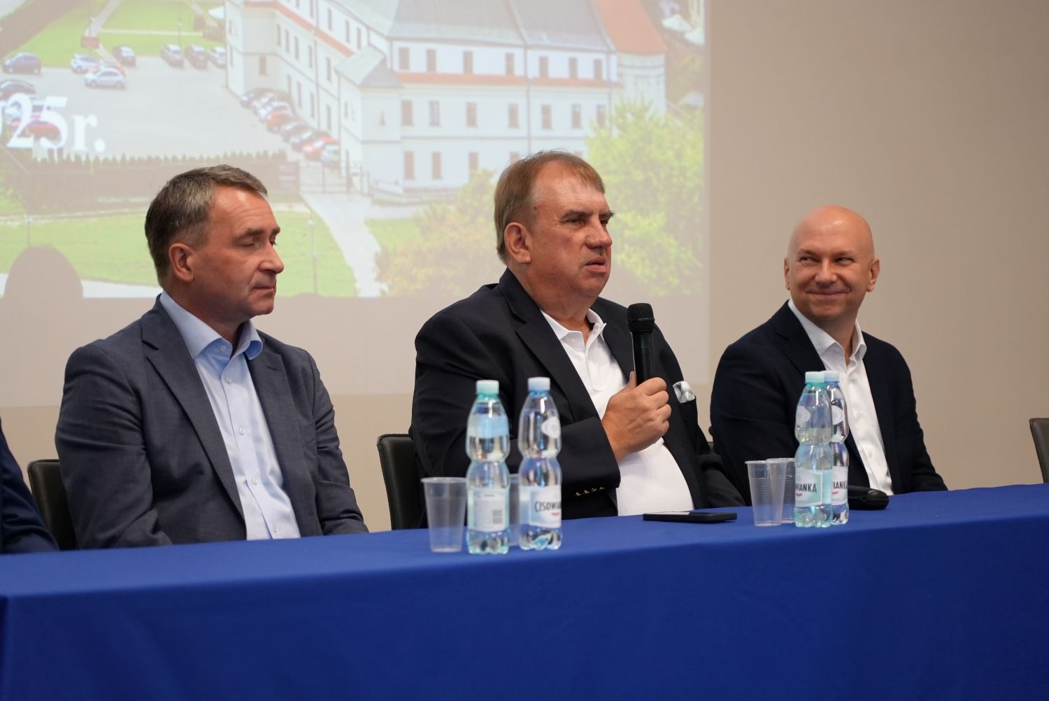 rektor i dwóch mężczyzn zasiadających przy stole