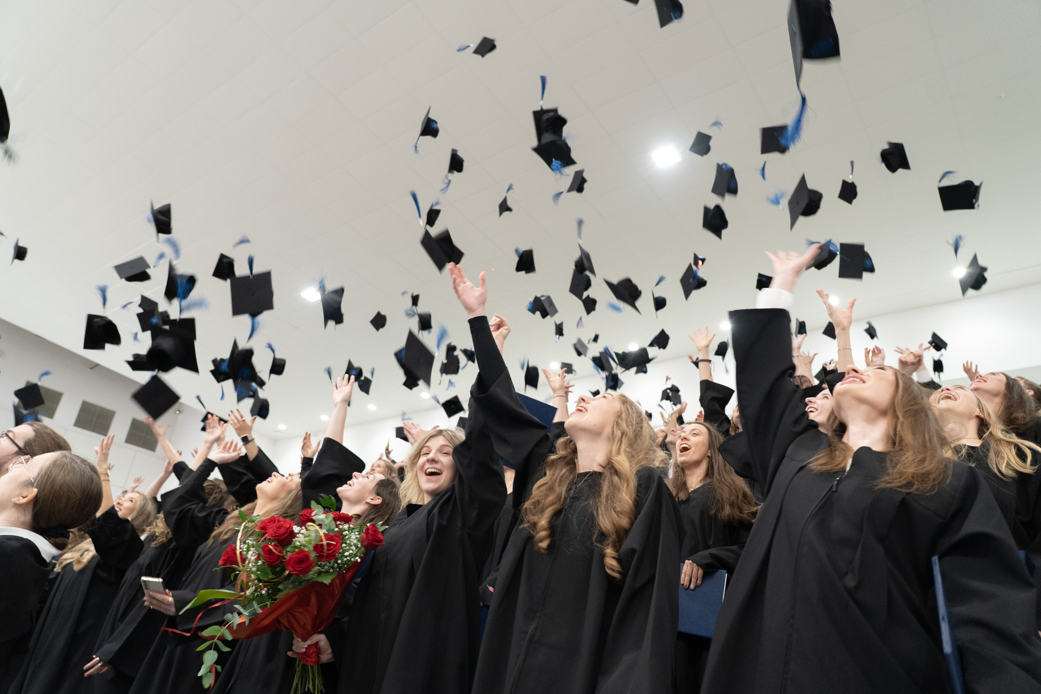 studenci podrzucają birety do góry