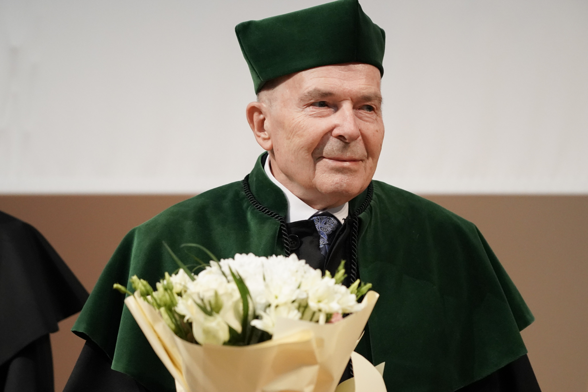 doktor honoris causa z bukietem kwiatów 