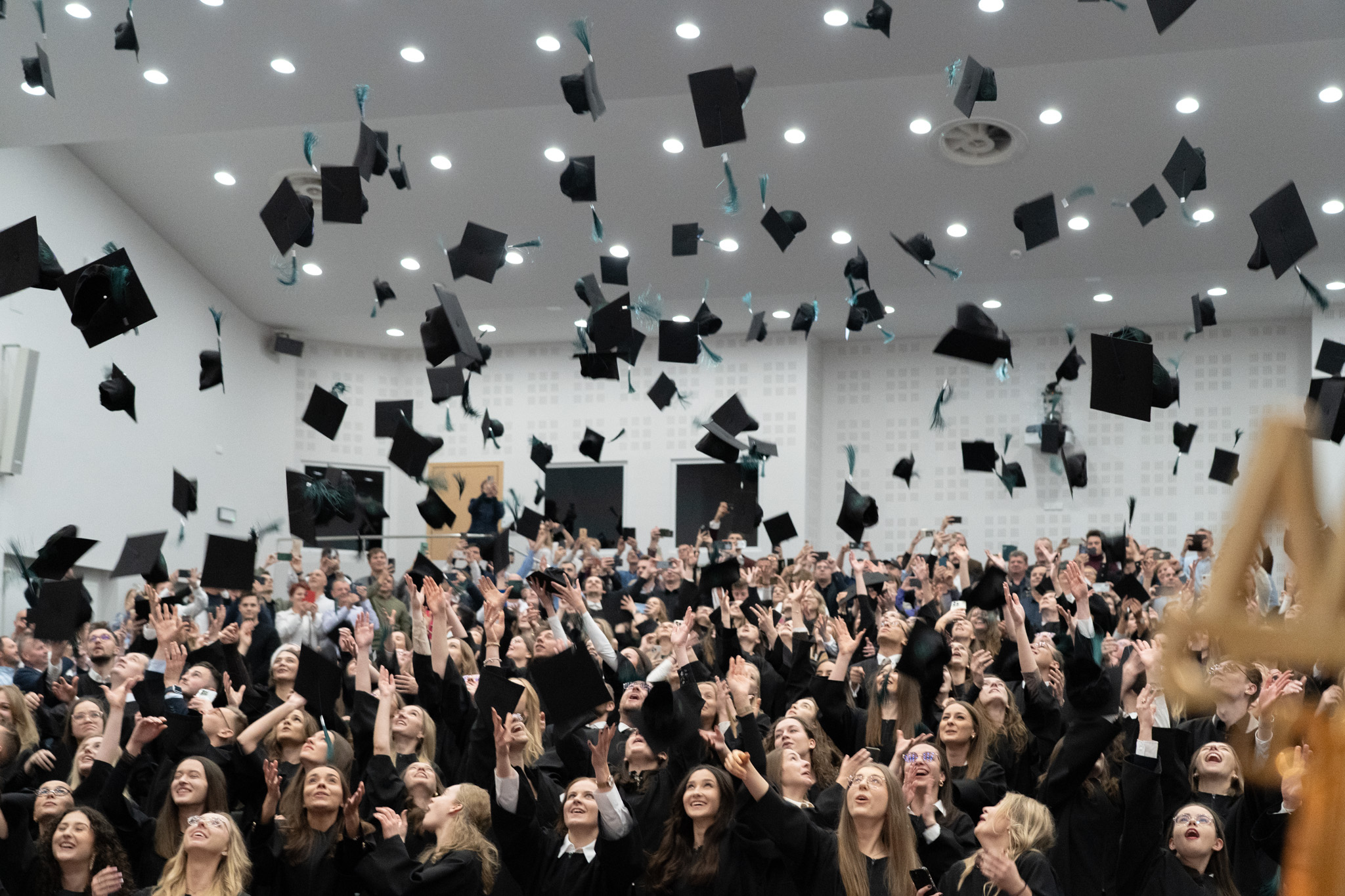 studenci podrzucają birety do góry