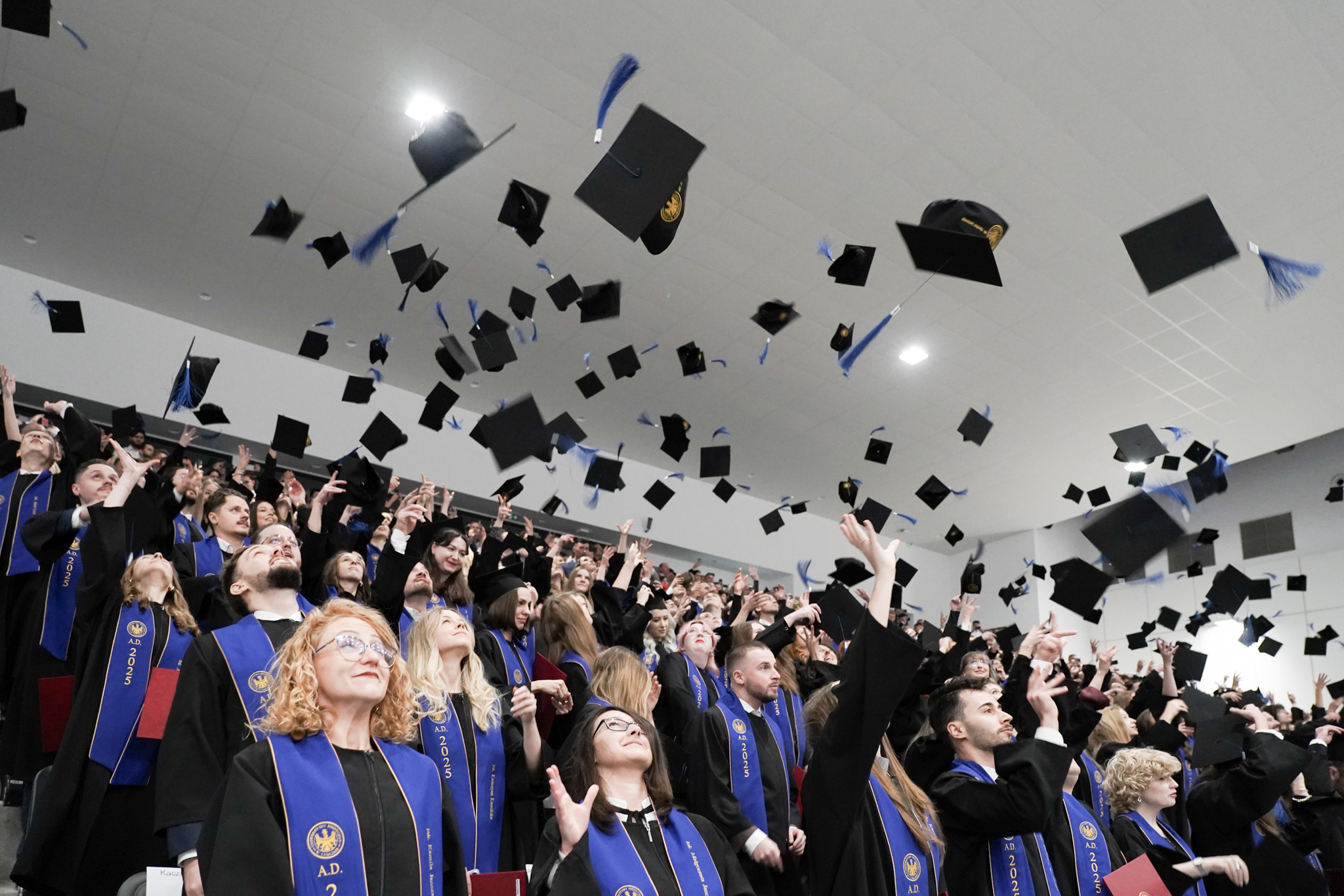 uroczyste dyplomatorium, absolwenci podrzucają birety