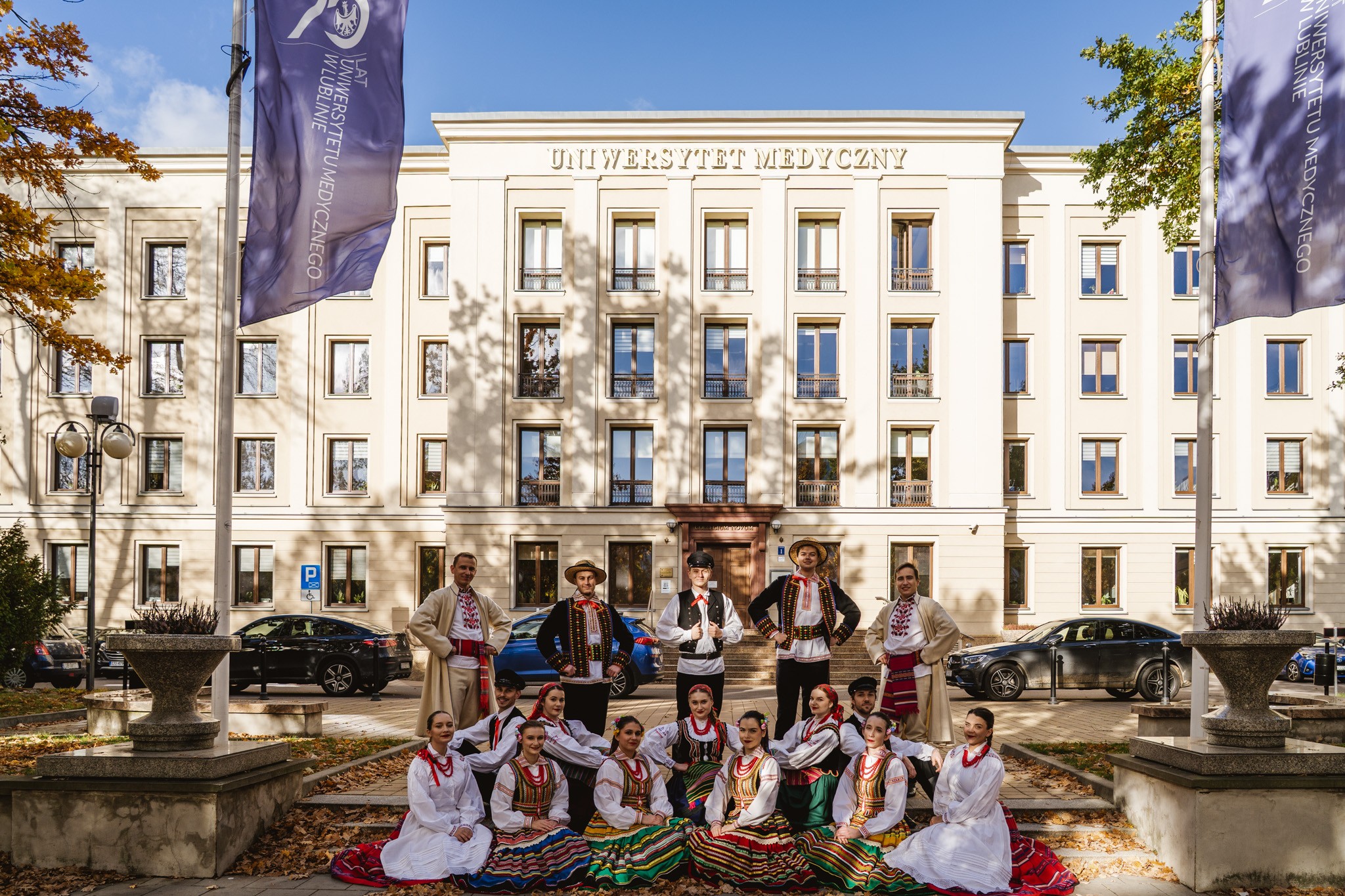 Zespół Pieśni i Tańca UMLub w ludowych strojach na tle budynku Collegium Novum