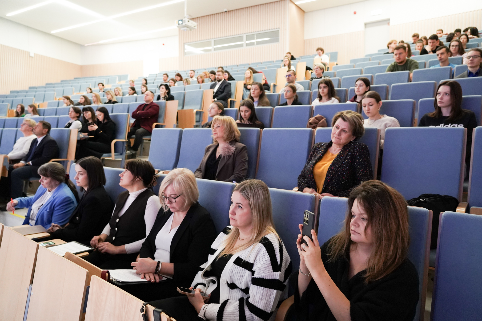 uczestnicy konferencji zasiadają na auli i słuchają wykładu
