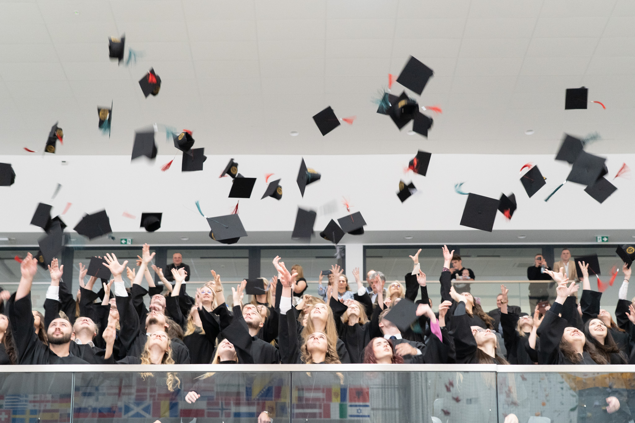 studenci podrzucają birety do góry