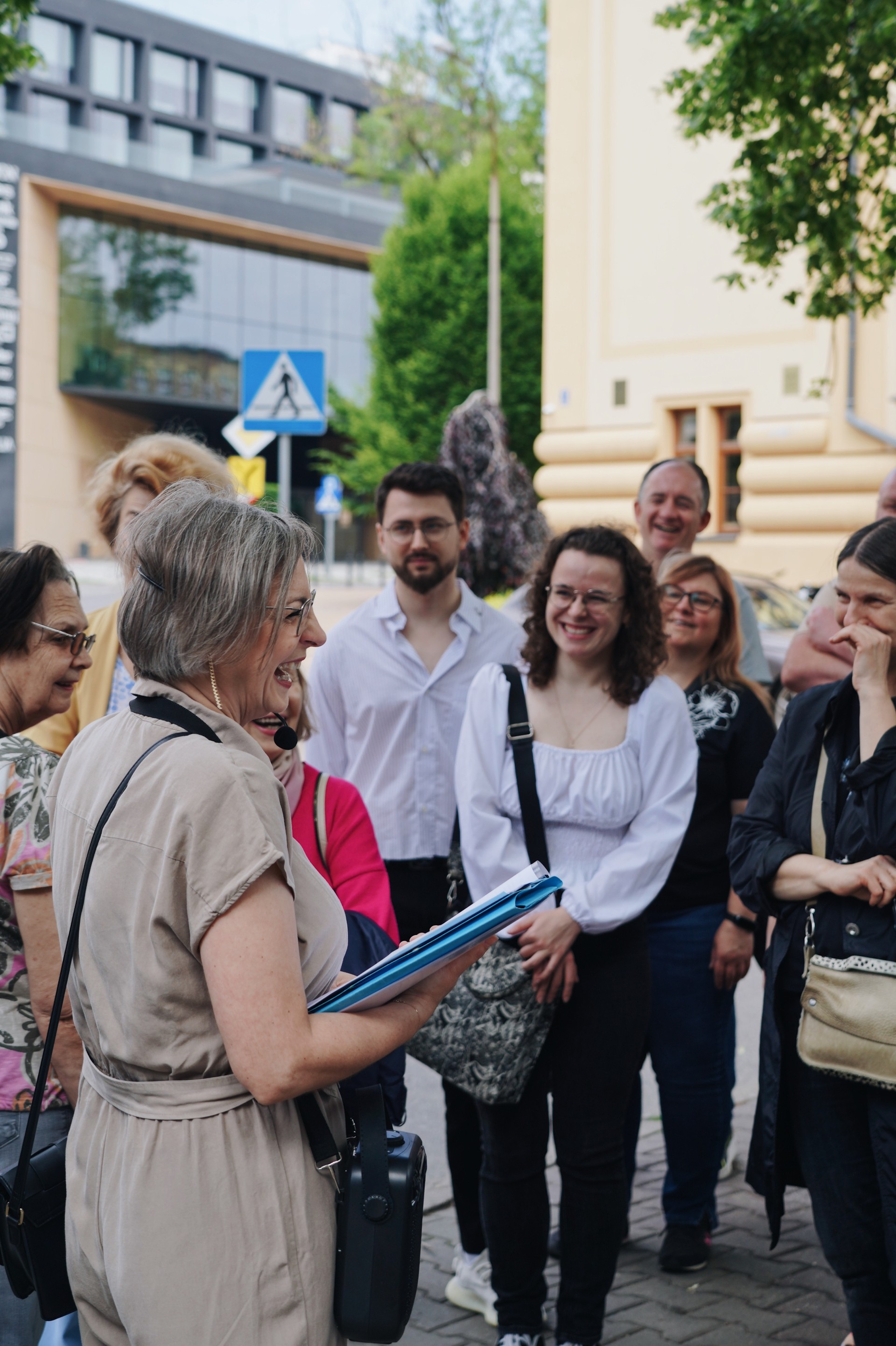 uczestnicy spaceru i przewodnika śmieją się i rozmawiają