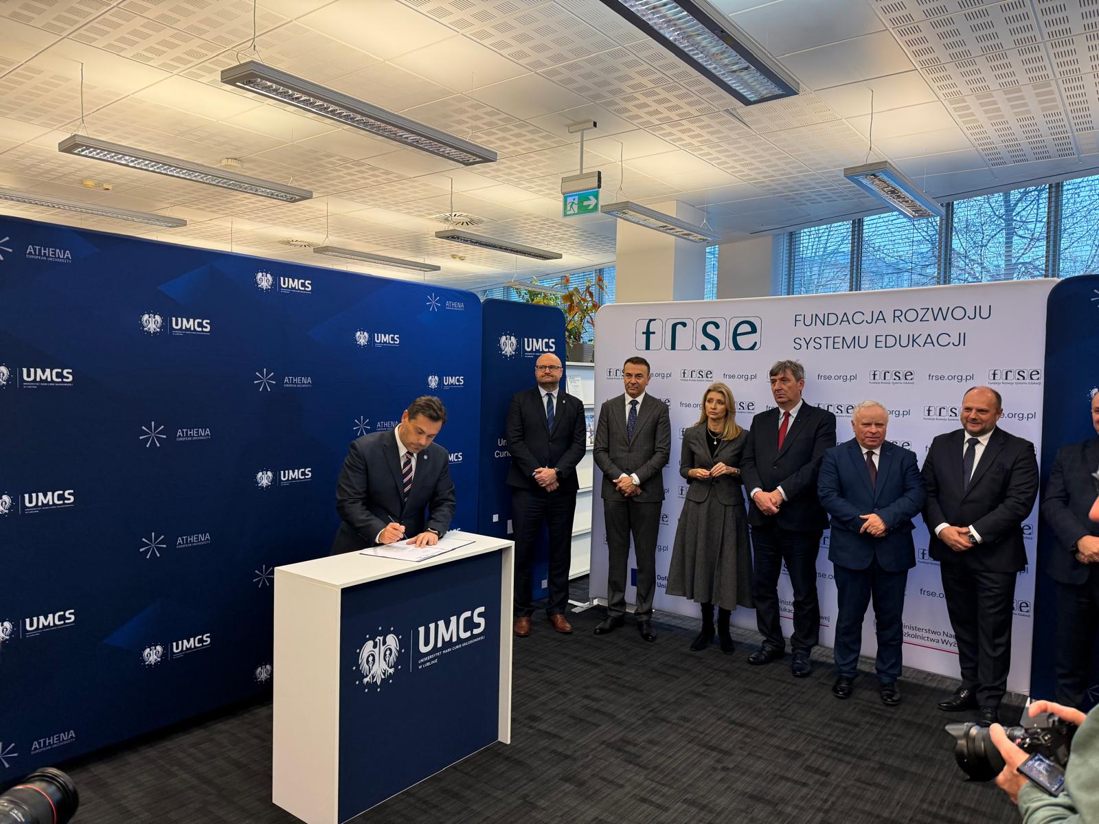 rektor Torres podpisuje dokument, w tle władze pozostałych członków projektu