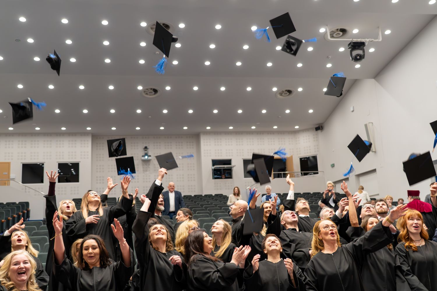 studenci podrzucają birety do góry