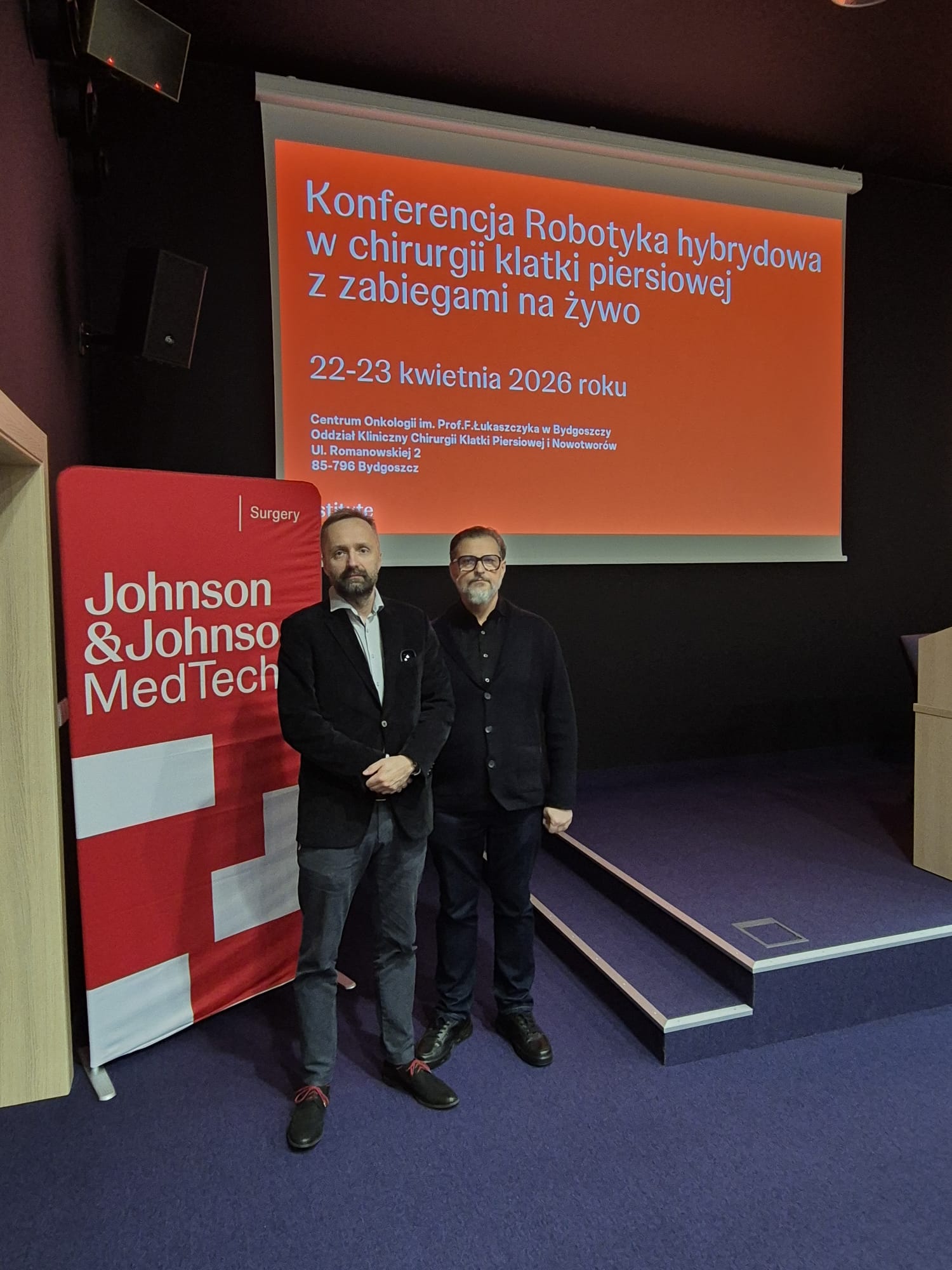 dr hab. Paweł Rybojad oraz dr Piotr Skoczylas na tle slajdu z nazwą konferencji 