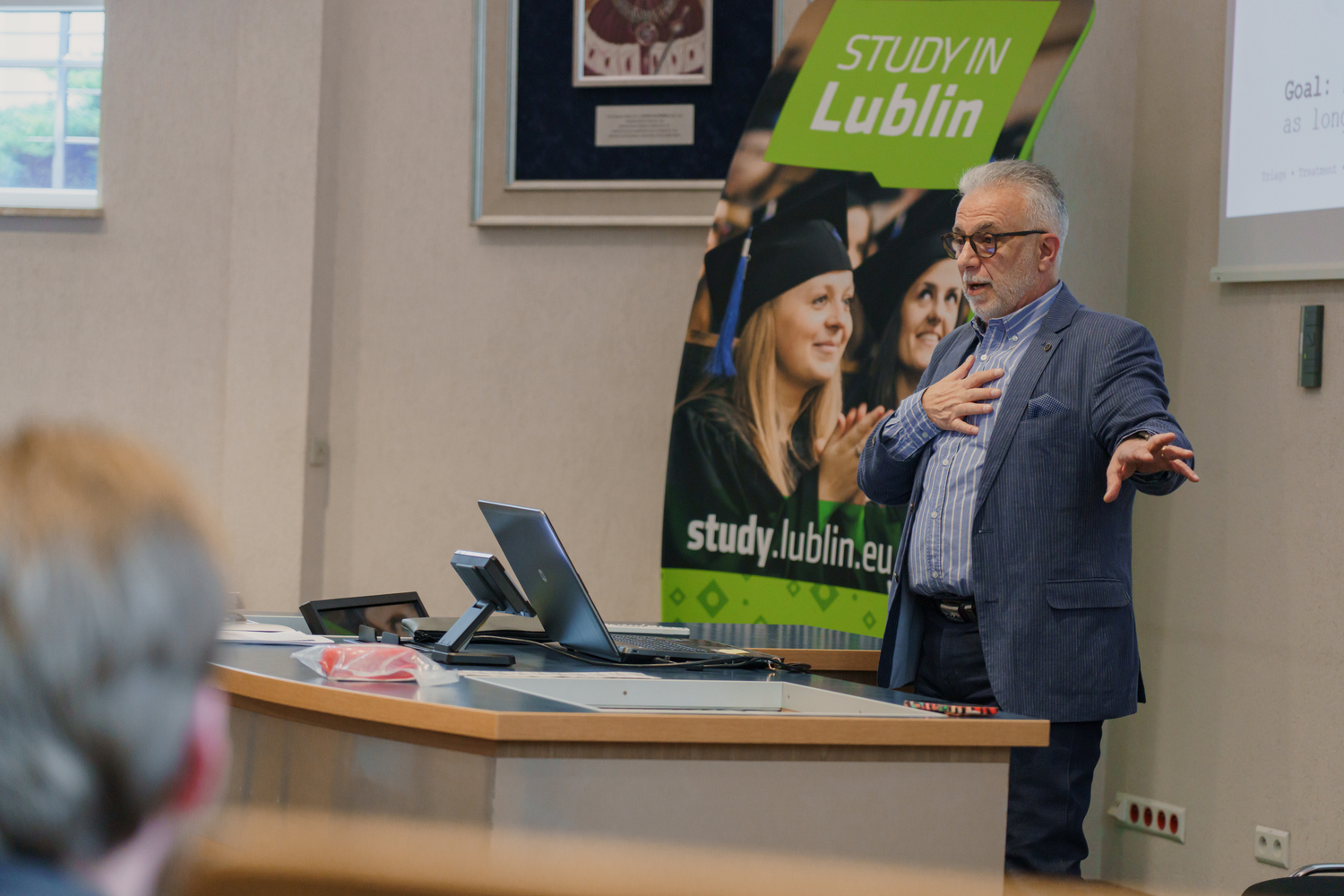  prof. Amir Khorram-Manesh przemawia na auli, w tle baner Study in Lublin
