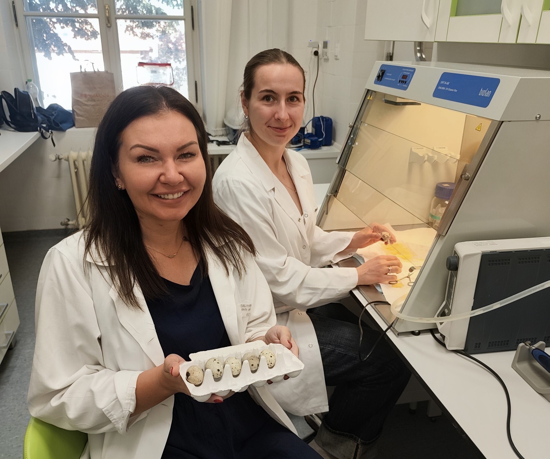 dwie kobiety w laboratorium uśmiechają się do zdjęcia